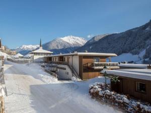 a snow covered street with buildings and mountains in the background at Apartment Maisonnette Im Wald 1 in Wald im Pinzgau