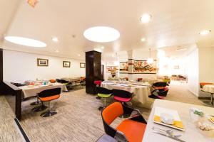a restaurant with tables and chairs in a room at Hôtel Hélios in Juan-les-Pins