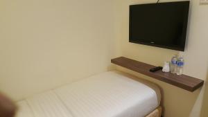 a small room with a bed and a flat screen tv at 9 Square Hotel - Seri Kembangan in Seri Kembangan