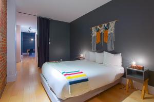 a bedroom with a large white bed with a colorful blanket at Les Lofts St-Joseph - Par Les Lofts Vieux-Québec in Quebec City