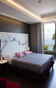 a bedroom with a large bed with a large window at Hotel Vittorio in Desenzano del Garda