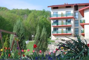 a building with flowers in front of it at Park Hotel Ribaritsa in Ribarica