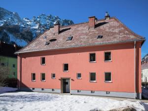 a large red building with mountains in the background at Erzberg Royal in Eisenerz