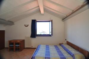 1 dormitorio con cama y ventana en North Wind Camping & Apartment, en Domaso