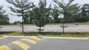 an empty parking lot with three trees in it at 9 Square Hotel - Seri Kembangan in Seri Kembangan