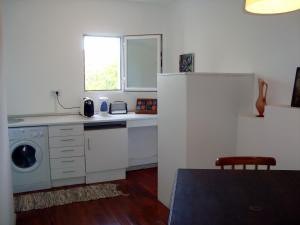 a kitchen with a sink and a washing machine at Casa do Jasmim in Sintra