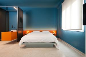 niebieska sypialnia z łóżkiem i oknem w obiekcie Syntagma Square Modern Apartments w Atenach