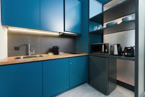 a kitchen with blue cabinets and a sink at Syntagma Square Modern Apartments in Athens