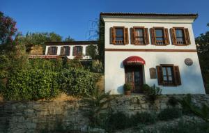 Ein weißes Haus mit einer roten Markise darauf. in der Unterkunft Terrace Houses Sirince in Selçuk