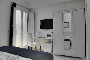 a bedroom with a desk with a computer and a television at Due Passi Dal Mare in Noto Marina