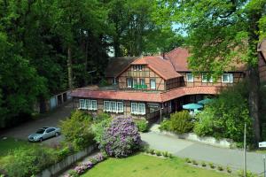 ein Haus mit einem davor geparkt in der Unterkunft Hotel Schnehagen in Bad Fallingbostel