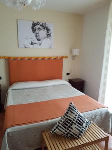 a bedroom with a bed with an orange headboard and a table at B&B La Casa Di Zefiro in Limite