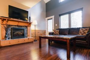a living room with a couch and a fireplace at Marblewood Village Resort in Steady Brook