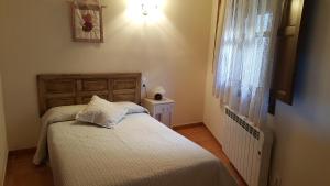 a small bedroom with a bed and a window at Casa Sampietro in Alquézar