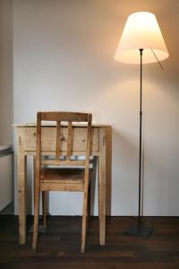 uma secretária de madeira com uma cadeira e um candeeiro em Posta Veglia em Laax