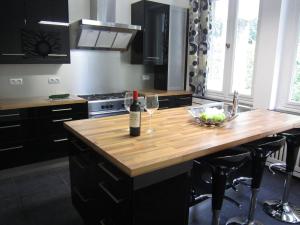 a kitchen with a wooden counter top with a bottle of wine at Luxurious countryside holiday home with pool in Malmedy