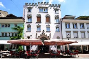 um edifício com mesas e guarda-chuvas à sua frente em Hotel Loge em Winterthur