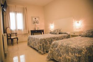 A bed or beds in a room at Hotel El Capricho