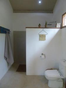a white bathroom with a toilet and a sink at Abaetetuba Pousada in São Miguel dos Milagres