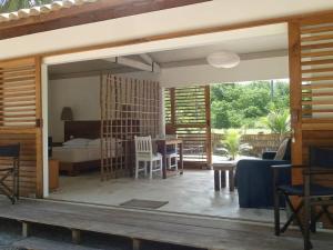 a living room with a bed and a table and chairs at Abaetetuba Pousada in São Miguel dos Milagres