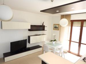 a living room with a television and a dining room table at Appartamento Carino Splendido Trivano Panoramico IUN S3308 in Quartucciu