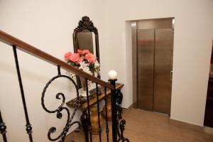 a staircase with a mirror and a vase of flowers at Hotel El Capricho in Villanueva del Trabuco