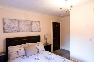 a bedroom with a bed and a painting on the wall at Belford House Self Check-in Rooms in Haltwhistle