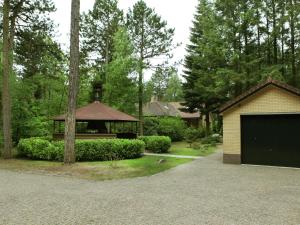 a house with a garage and a building at Cosy villa in the middle of the woods in Doornspijk in Doornspijk