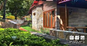 a stone house with a window and a stone wall at Natura Reservado - Hoteles Natura in Anapoima