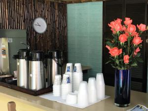 a counter with a vase of orange flowers and a coffee maker at Douglas House in Key West