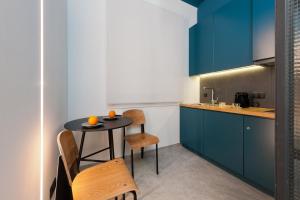 kuchnia z niebieskimi szafkami oraz stołem i krzesłami w obiekcie Syntagma Square Modern Apartments w Atenach +7 zdjęć
