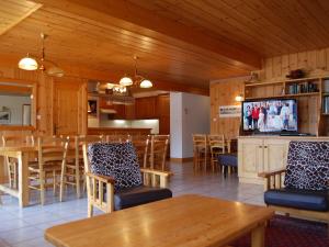 a dining room with tables and chairs and a television at Beautiful south facing chalet in Le Villard