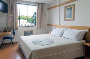 Ένα ή περισσότερα κρεβάτια σε δωμάτιο στο Grande Hotel Guarapuava +40 φωτογραφίες