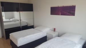 Zimmer mit 2 Betten und einem Bild an der Wand in der Unterkunft Apartment Weitblick Hannover in Hannover