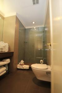 a bathroom with a toilet and a glass shower at Radio City Apartments in New York