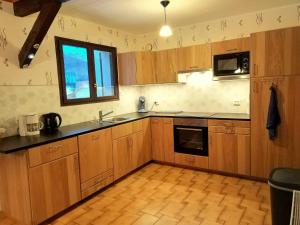 a large kitchen with wooden cabinets and a window at Chalet with mountain views in Laffrey