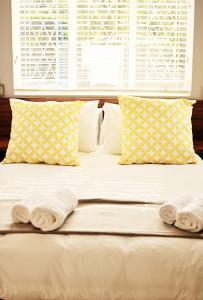 een bed met handdoeken en een raam bij Stel26 in Bloemfontein