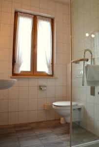 a bathroom with a toilet and a sink and a window at Gasthof Hotel Esterer in Rosenheim