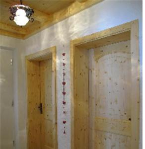zwei Holztüren in einem Zimmer mit einer Decke in der Unterkunft Apartment Großvenedigerblick in Neukirchen am Großvenediger