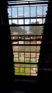 une fenêtre dans un bâtiment avec vue sur un champ dans l'établissement Don Santiago Guesthouse Downtown, à San Ignacio