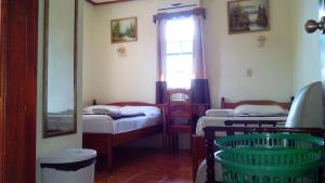 a small room with two beds and a window at Don Santiago Guesthouse Downtown in San Ignacio