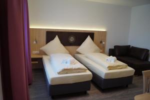a hotel room with two beds and a couch at Hotel Gasthaus Sonne in Peißenberg