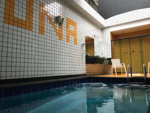 uma piscina com uma mesa e duas cadeiras ao lado de um edifício em Luna Motel em São Bernardo do Campo