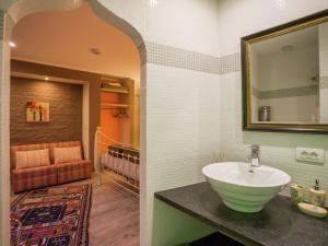 La salle de bains est pourvue d'un lavabo et d'un miroir. dans l'établissement Very nice manor house in North African atmosphere, à Courtrai