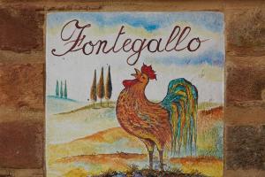 un signe avec une photo d'un poulet dans un champ dans l'établissement Podere Fontegallo, à Castiglione del Lago