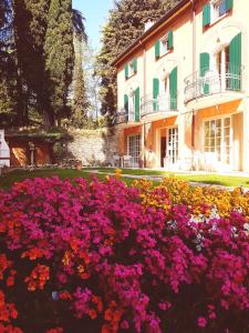 a garden of flowers in front of a building at Residenza Eden in Colà di Lazise