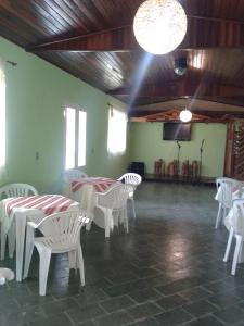 a room with white tables and white chairs and a spotlight at Pousada Recanto Águas Vivas com Piscina Aquecida e Lazer Completo próximo a Sorocaba in Turvo dos Góis