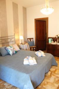 um quarto com uma cama grande e toalhas em Affittacamere Casa Mac & Rose em San Quirico dʼOrcia