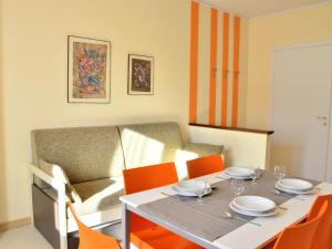 a dining room with a table and orange chairs at Belvilla by OYO Argentina Tre in Lazise
