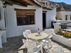 a patio with a table and chairs on a balcony at Casas Rurales Encarnita in Bubión